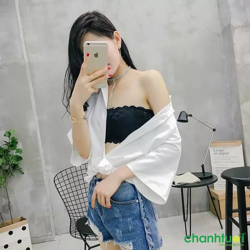 alt text: Một cô gái diện áo bra ren đen bên trong áo sơ mi trắng oversized, tạo nên vẻ ngoài vừa gợi cảm vừa phóng khoáng.